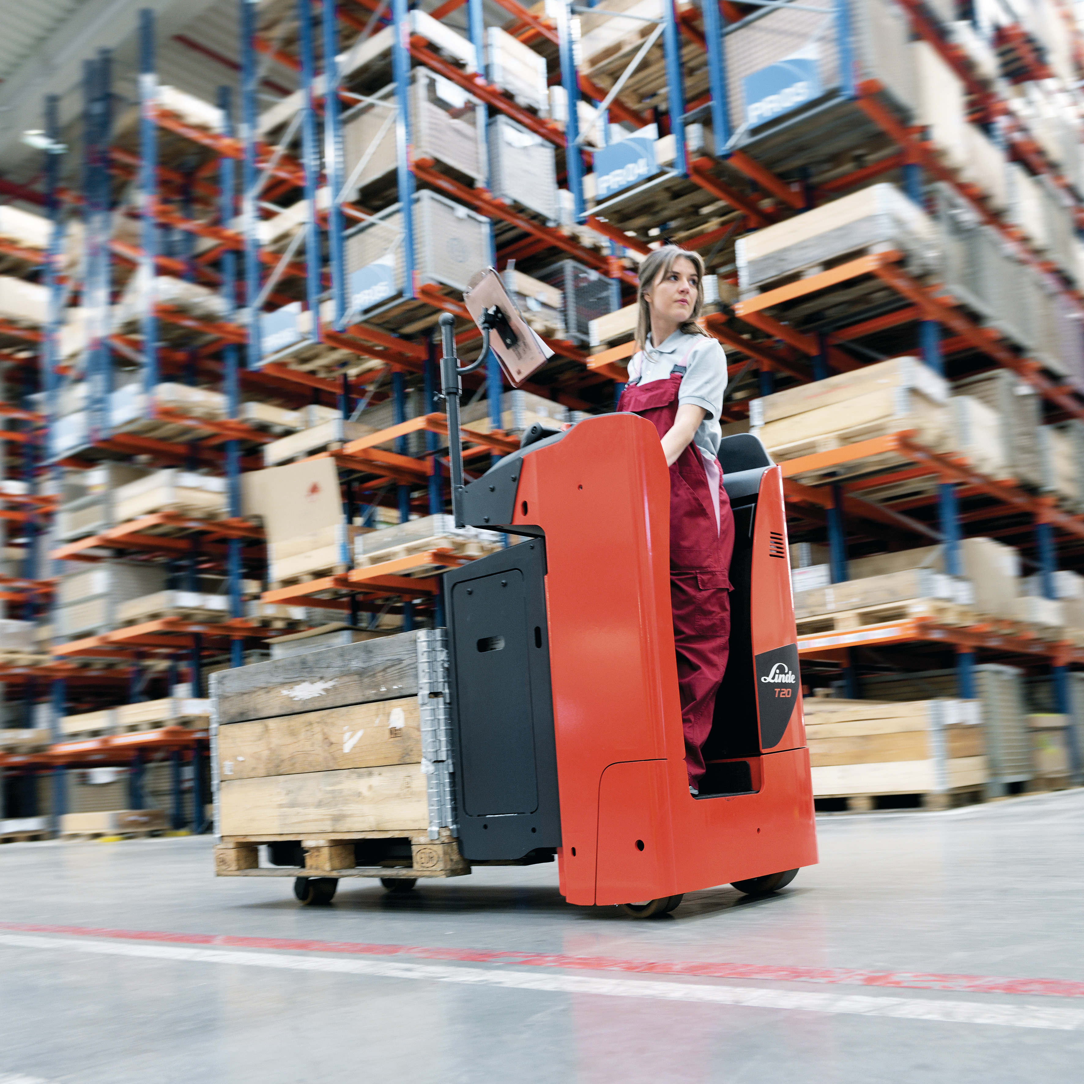 Linde T20S met vrouw rijdt pallets door warehouse